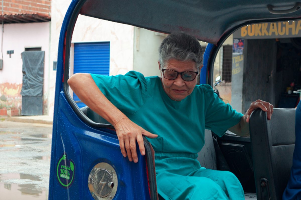 Usuária idosa em um tuk-tuk da Rede Vamos Juntos